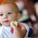 Toddler eating boiled egg
