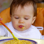Baby age of 1 year eats rice-milk with pumpkin