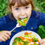 Child Eats Vegetables. Summer Photo. Selective Focus